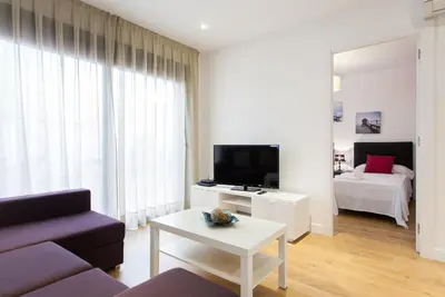 a living room with a couch and a tv and a bed at Key San Pau House Terrace - Barcelona in Barcelona