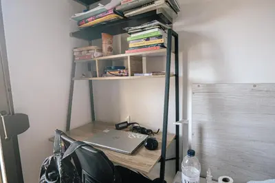 a desk with a laptop on a shelf with books at Cotonat in El Arrabal