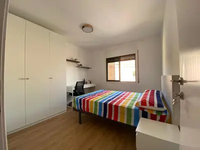 a bedroom with a colorful bed and a desk at Cotonat in El Arrabal