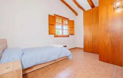 a bedroom with a bed and a wooden cabinet at Beautiful Home In Guardiola De Fontrubí in La Guardiola