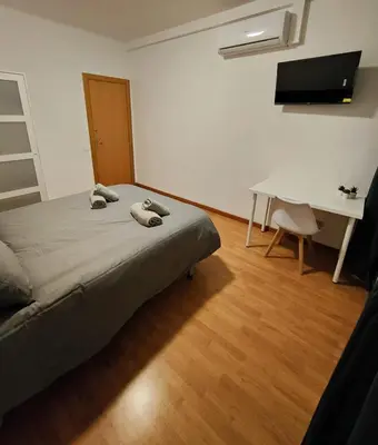 a bedroom with a bed and a desk and a table at Apart Granollers Centre in Granollers