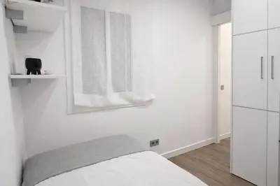 a white bedroom with a bed and a mirror at Opening Doors Poblenou Beach in Barcelona