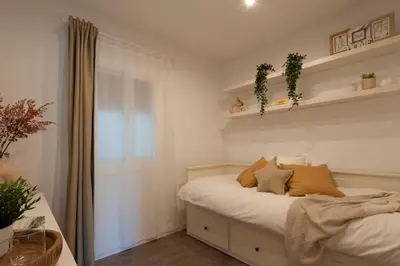a bedroom with a bed and a window and shelves at Opening Doors Poblenou Beach in Barcelona