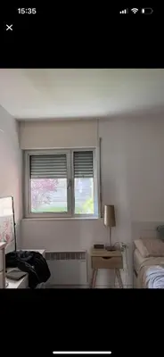a bedroom with two windows and a table with a lamp at Piso centro Sabadell 2 pax in Sabadell