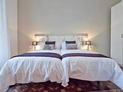 a white bedroom with a bed and a fireplace at Flateli Universitat in Barcelona