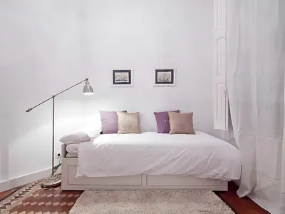 a room with a large wall filled with books at Flateli Universitat in Barcelona