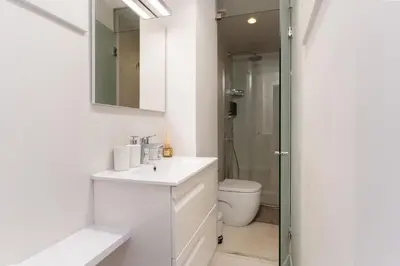 a white bathroom with a sink and a toilet at Penthouse with private terrace in the center in Barcelona