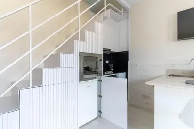 a kitchen with white walls and a white staircase at Penthouse with private terrace in the center in Barcelona