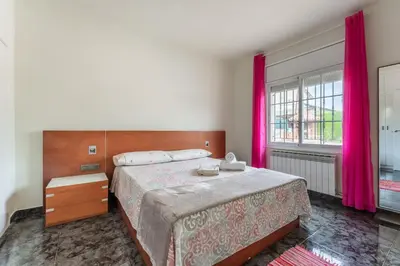 a bedroom with a large bed with pink curtains at Casa de vacances Mary in Santa Eulalia de Ronsaná