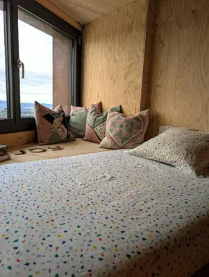 a bedroom with a bed with pillows and a window at AranEtxea in Bigues i Riells