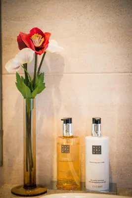 a vase with a flower and a bottle on a shelf at Opening Doors Pueblonuevo in Barcelona