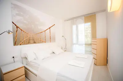 a white bedroom with a bridge painting on the wall at Opening Doors Pueblonuevo in Barcelona