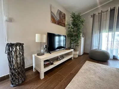 a living room with a flat screen tv on a white cabinet at Casa Salud in Piera