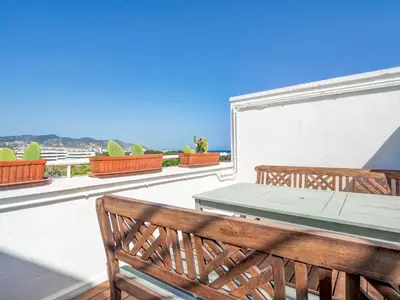 a patio with a table and benches on a balcony at Panoramic Terraces by Hello Homes Sitges in Sitges
