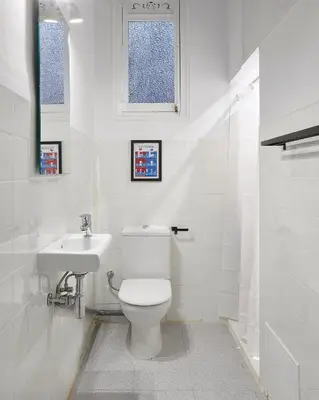 a white bathroom with a toilet and a sink at Girona 46 - 1 in Barcelona