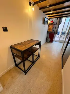 a wooden table sitting in the corner of a room at Precioso estudio con terraza en Florida E1 in Hospitalet de Llobregat