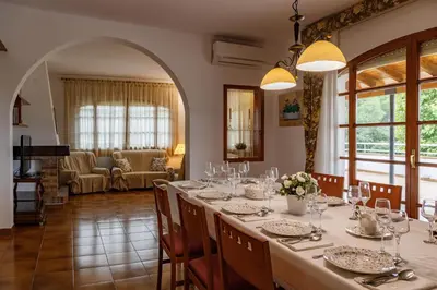 a dining room with a long table and chairs at Casa Fontanals in Pla del Panadés