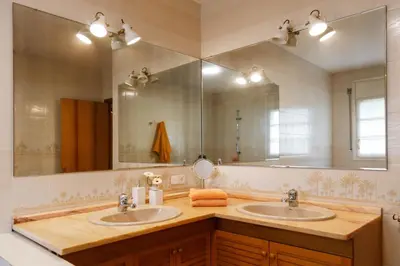a bathroom with two sinks and a large mirror at Casa Fontanals in Pla del Panadés