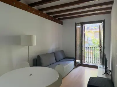 a living room with a couch and a window at Homenfun Barcelona Hospital Clínic l in Barcelona