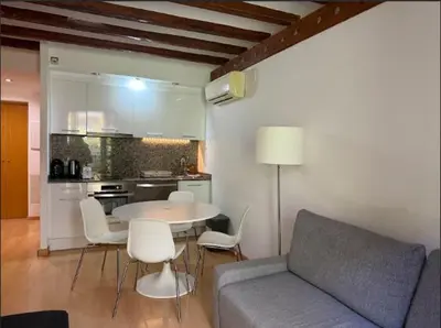 a living room with a couch and a table and chairs at Homenfun Barcelona Hospital Clínic l in Barcelona