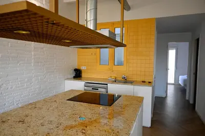 a kitchen with yellow walls and a counter top at Homenfun Barcelona plaza Joanic in Barcelona