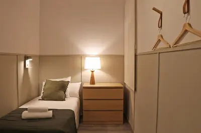 a small bedroom with a bed and a lamp at Sagrada Familia - The Haus Bcn in Barcelona