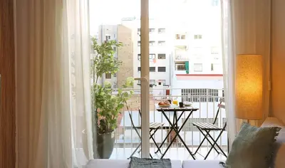 a living room with a couch and a balcony with a table at Sagrada Familia - The Haus Bcn in Barcelona