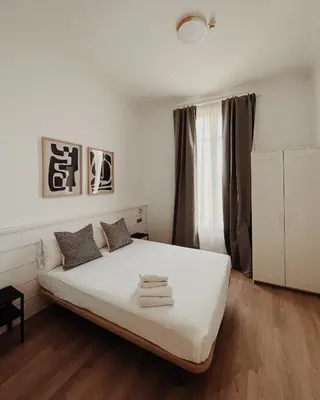 a bedroom with a white bed with towels on it at Apartamentos Express by gaiarooms in Barcelona