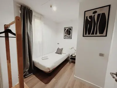 a small white room with a bed and a window at Apartamentos Express by gaiarooms in Barcelona