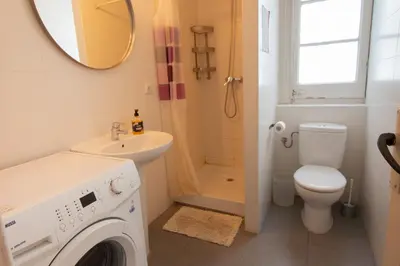 a bathroom with a toilet sink and a washing machine at Barcelona Classic Eixample Apartments in Barcelona