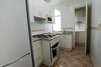 a white kitchen with a stove and a sink at Barcelona Classic Eixample Apartments in Barcelona