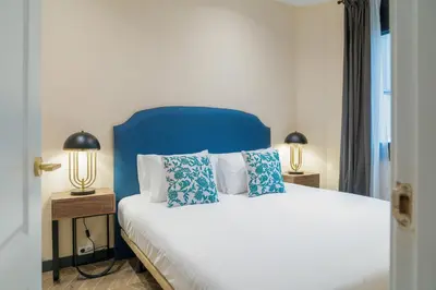 a bedroom with a bed with blue headboard and two lamps at Stay U-nique Apartment Putxet II in Barcelona