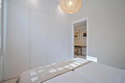 a white room with a bench and a table at Sitges Spaces Garden Condo-2 Bedrooms, 2 Bathrooms, Garden Terrace, Near center, Sleeps up to 6- Monthly Rentals Only in Sitges