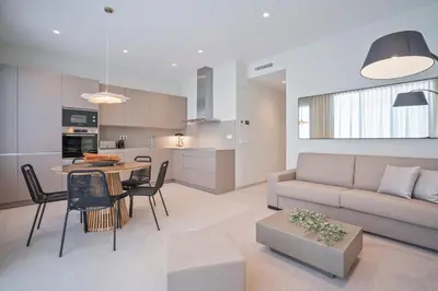 a living room and kitchen with a couch and a table at Sitges Spaces Garden Condo-2 Bedrooms, 2 Bathrooms, Garden Terrace, Near center, Sleeps up to 6- Monthly Rentals Only in Sitges