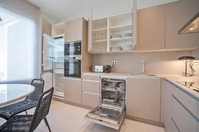 a kitchen with a table and chairs and a sink at Sitges Spaces Garden Condo-2 Bedrooms, 2 Bathrooms, Garden Terrace, Near center, Sleeps up to 6- Monthly Rentals Only in Sitges