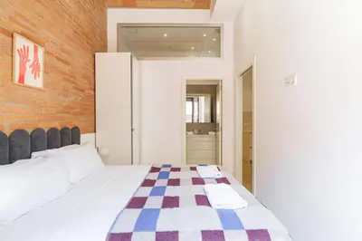 a bedroom with a bed and a brick wall at GuestReady - Lovely home in the heart of Barcelona in Barcelona