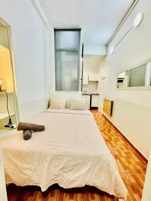 two beds in a room with a large window at O43 Center Barça 4 3 in Barcelona