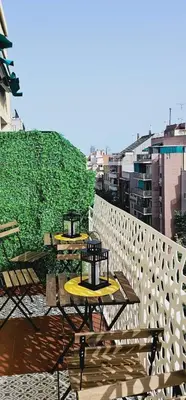 two tables on a balcony with a green wall at Apartamento exclusivo junto Sagrada Familia Barcelona in Barcelona