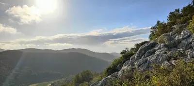 a view of a mountain with the sun shining on it at Ànima del Garraf in Sitges