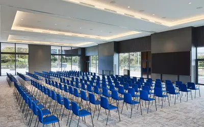 a large room with blue chairs and a screen at Four Points by Sheraton Barcelona Airport in Barcelona