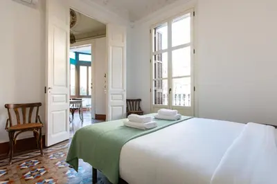 a bedroom with a large white bed with towels on it at BP2 - Big apartment for groups in BCN city center HUTB - 77390 in Barcelona