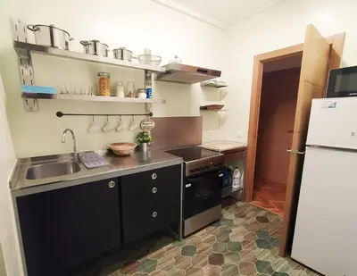 a small kitchen with a sink and a refrigerator at Spacious apartment in the heart of the city in Barcelona