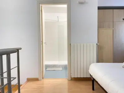 a white bathroom with a shower and a sink at Duplex in Gracia in Barcelona