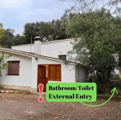 a house with a green sign in front of it at Hidden Garden Haven for 7 People in Vallromanas