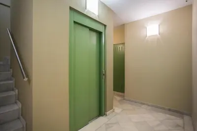 a green door in a hallway with stairs at Palau de la música 1 in Barcelona