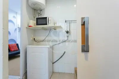 a bathroom with a washing machine and a tv at Estudio en Gracia in Barcelona