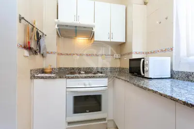 a kitchen with white cabinets and a microwave at Loft en Gracia II in Barcelona