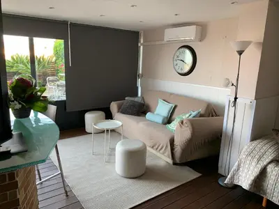 a living room with a couch and a clock on the wall at Apartamento con piscina y barbacoa cerca de Barcelona in Teià