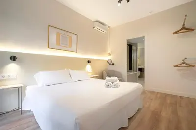 a bedroom with a white bed with two stuffed animals on it at Happy Apartments in Barcelona