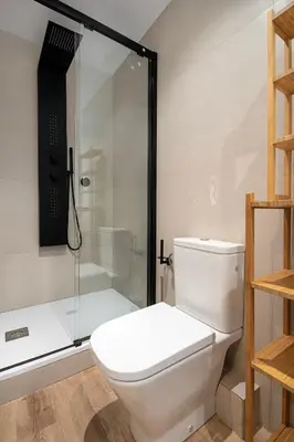 a bathroom with a white toilet and a shower at Happy Apartments in Barcelona